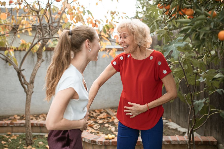 Two women laughing together in a garden