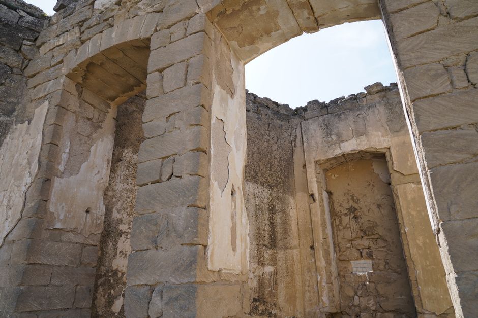 Historic stone ruins featuring arched doorways and weathered walls.