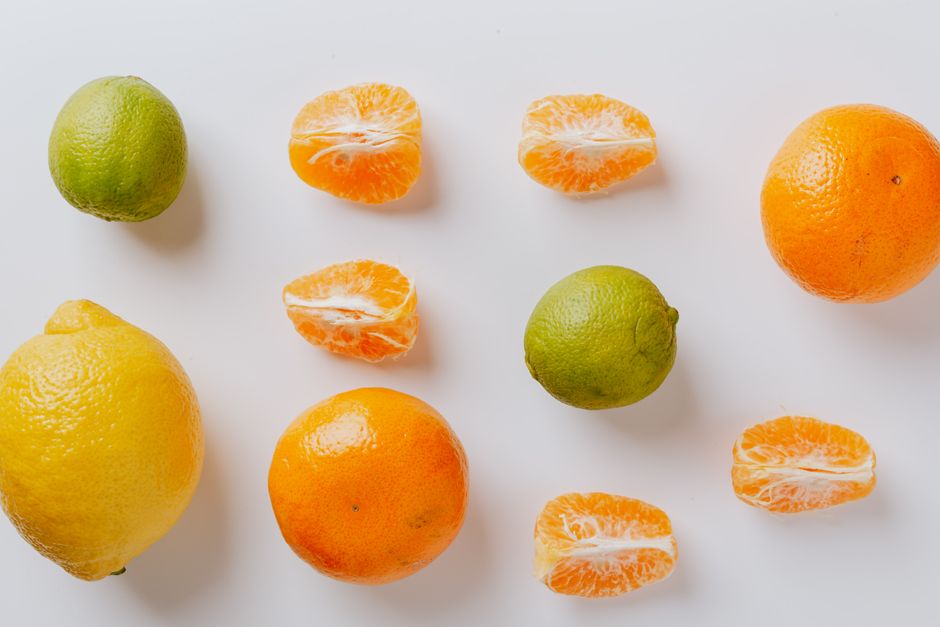 An arrangement of lemon, lime, and tangerine on a white surface highlighting freshness.