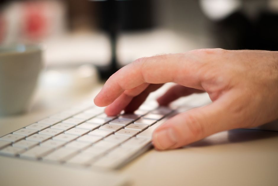 Close-up of a man typing on a keyboard, ideal for business themes.
