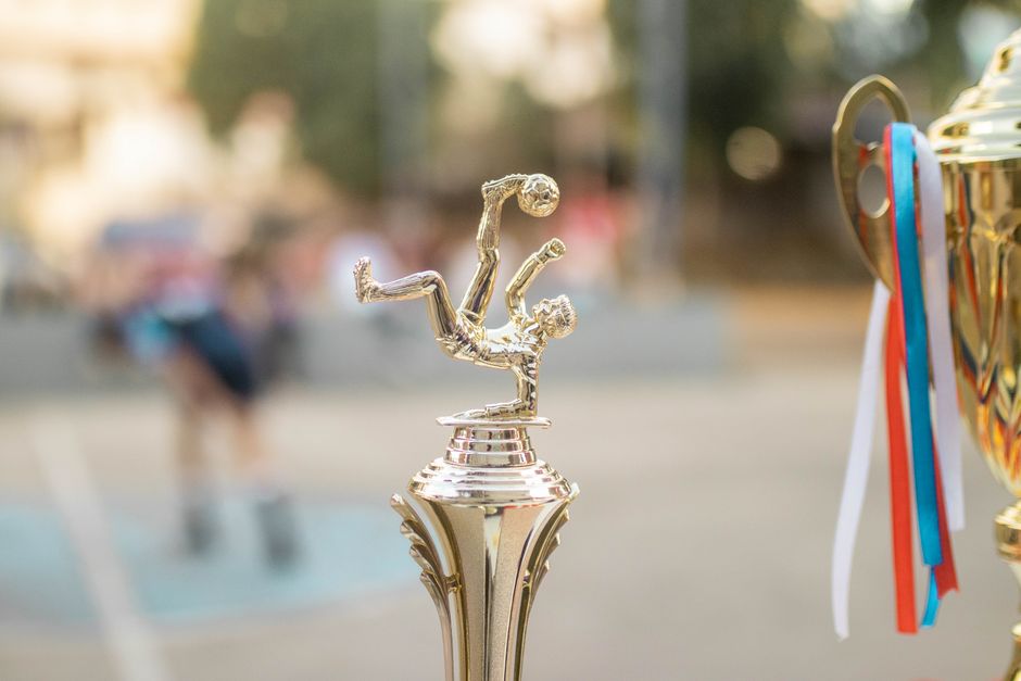 Golden football trophy with ribbons on display, capturing the essence of victory and sportsmanship.