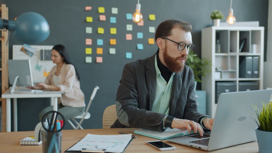Young professionals working in a modern office setting, emphasizing teamwork and focus.