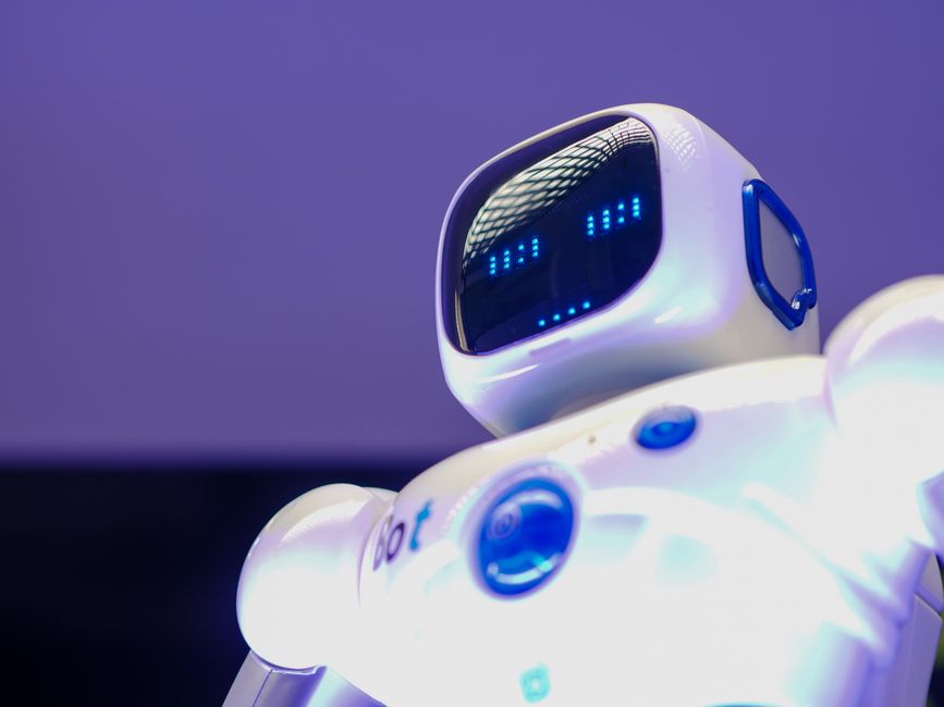 A modern humanoid robot with digital face and luminescent screen, symbolizing innovation in technology.