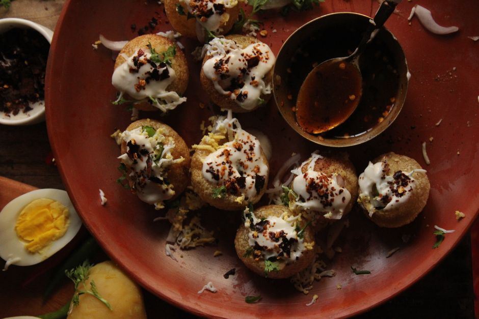 Tempting plate of Indian Pani Puri with spicy toppings and yogurt served with sauce.