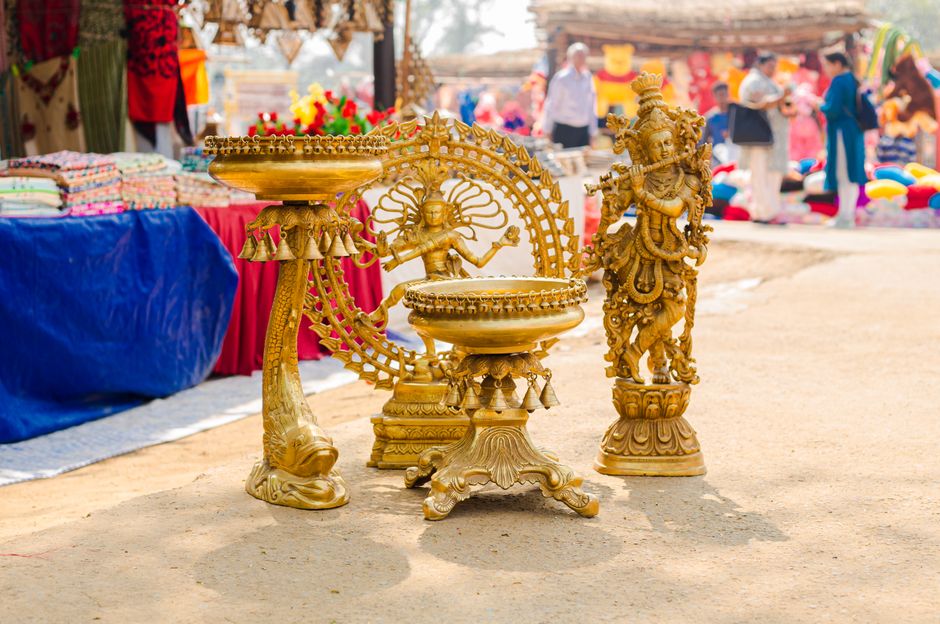 Golden sculptures displayed at vibrant outdoor market, showcasing traditional artistry and culture.