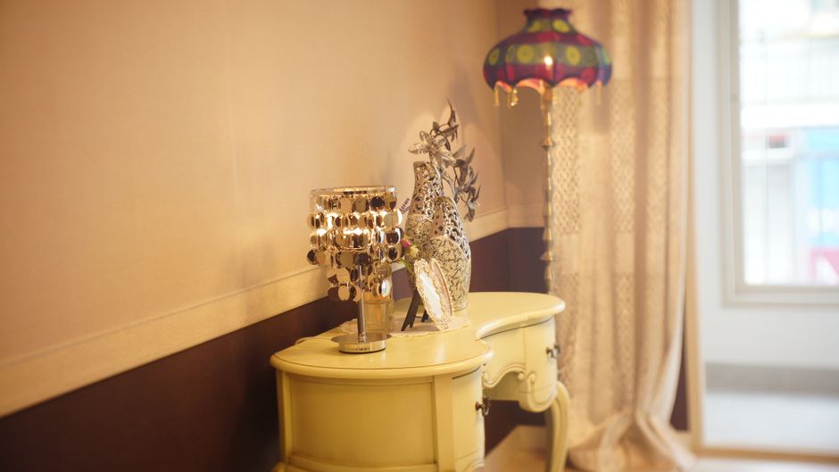 Luxury interior showcasing a stylish decorative table with a unique lamp and artistic figurine.