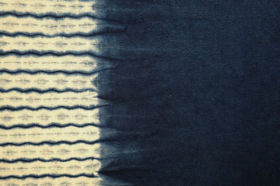 Close-up of indigo-dyed fabric featuring a wave pattern transitioning from light to dark blue.