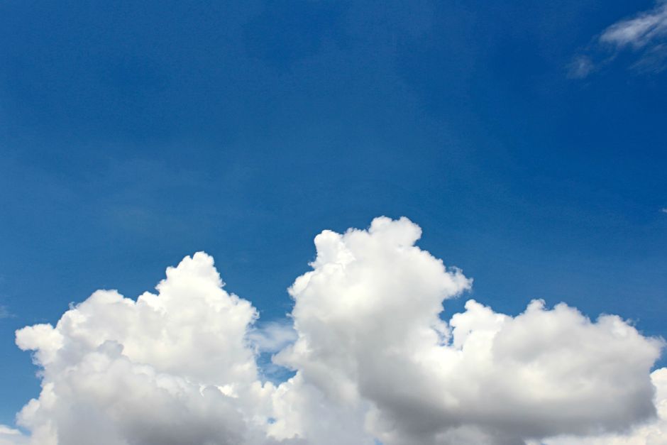 Vivid blue sky with white cumulus clouds on a clear day, perfect for backgrounds.