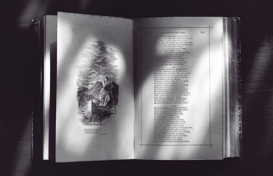 A black and white photo of an open book displaying text and an illustration.
