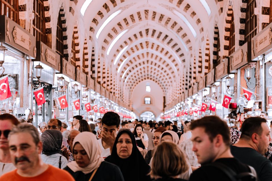 Bustling scene in Istanbul's historic Spice Bazaar, filled with diverse shoppers and vibrant colors.