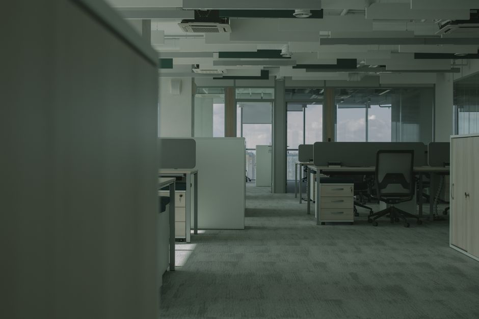 Spacious empty office featuring modern desks, chairs, and partitions.