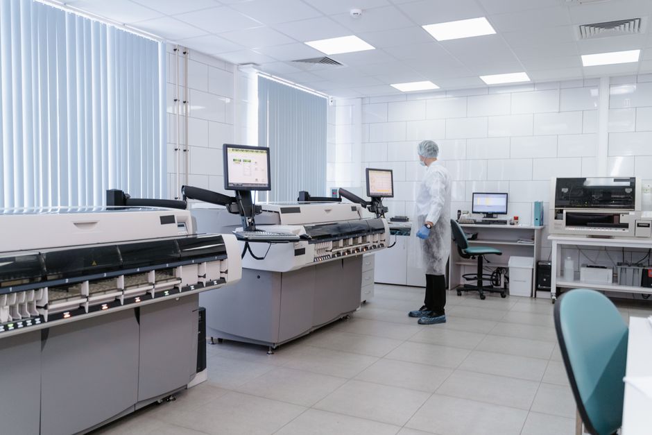 Scientist in a modern laboratory analyzing data on advanced equipment and monitors.