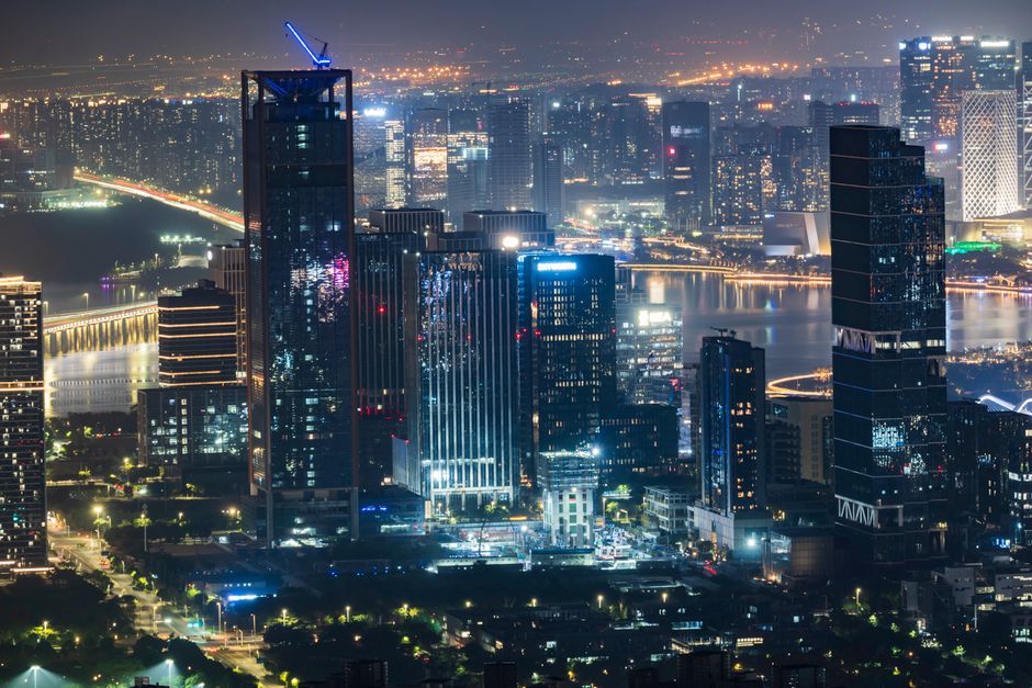 Vibrant city skyline at night showcasing illuminated skyscrapers and bustling city lights.