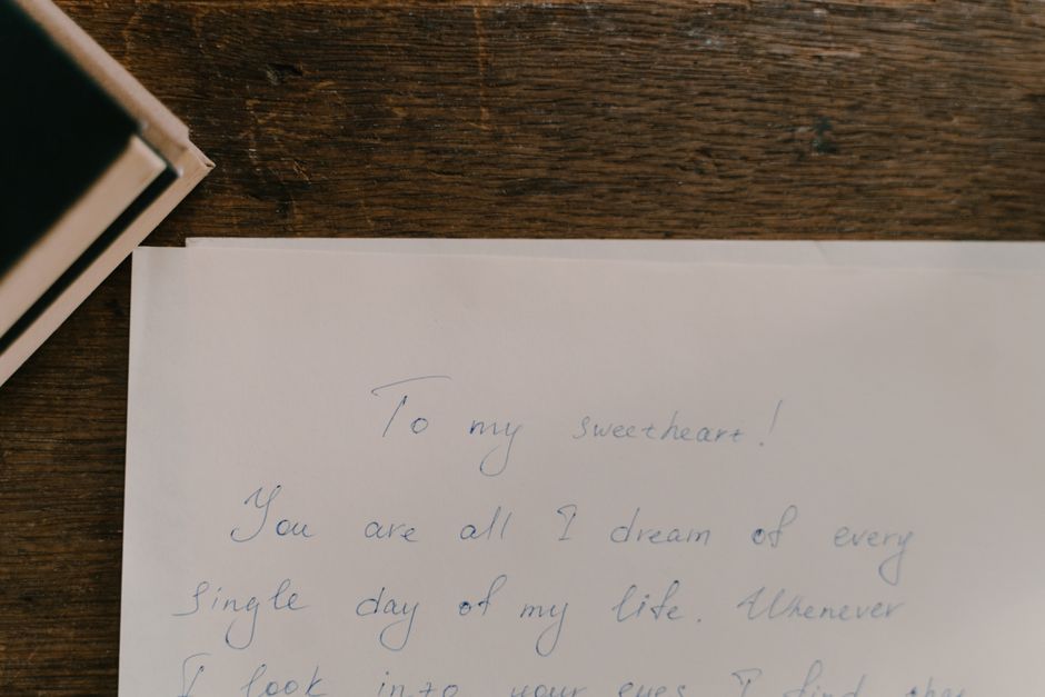 A heartfelt handwritten letter on paper placed on a wooden table.