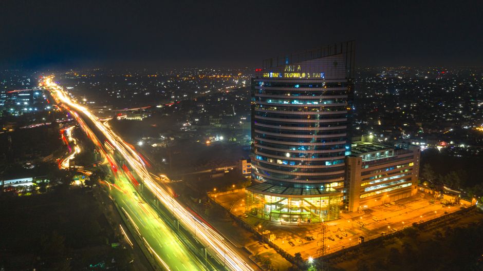 Stunning aerial night view of Arfa Software Technology Park in Lahore, showcasing city lights and traffic trails.