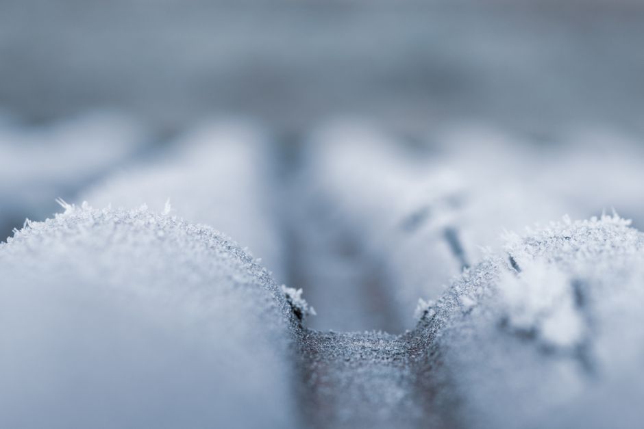 A detailed close-up shot of frost covering a cold roof surface during wintertime.