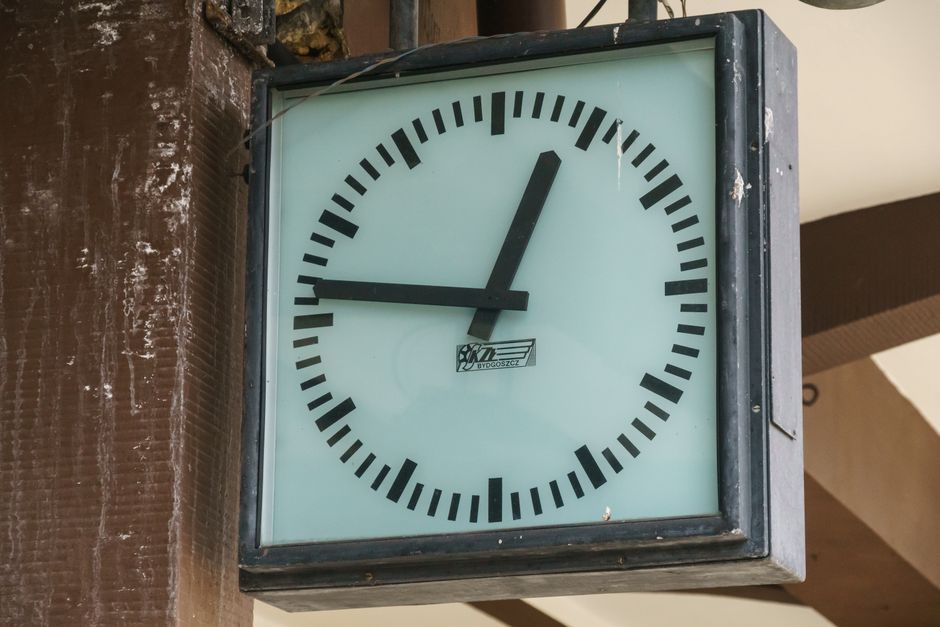 Close-up of a vintage analog clock at Krynica-Zdrój train station with a classic design.