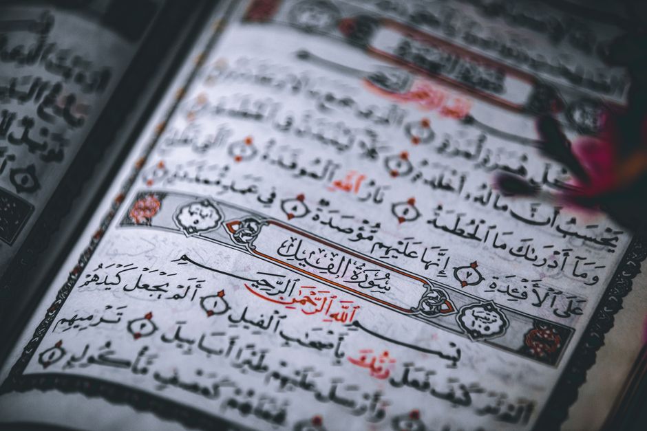 Detailed close-up of the Quran showing Arabic calligraphy and intricate designs.