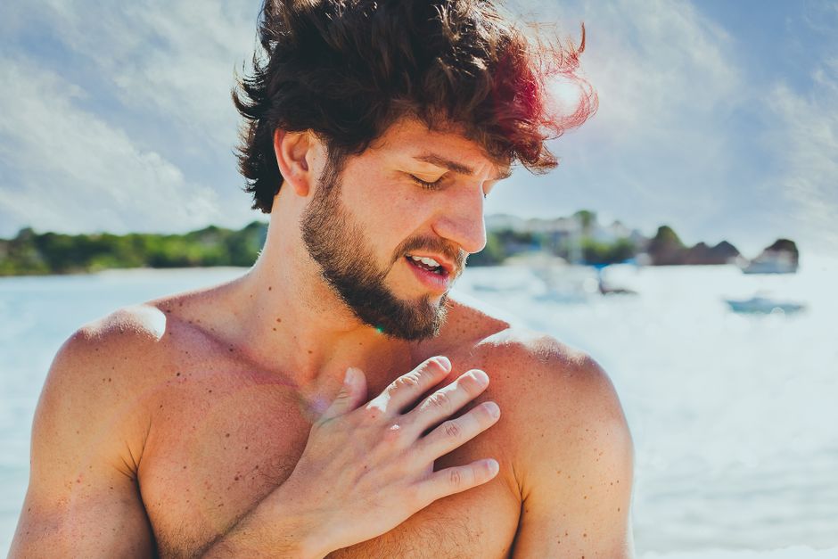 Young man with a beard enjoying a sunny day at Ilha do Boi beach in Brazil.