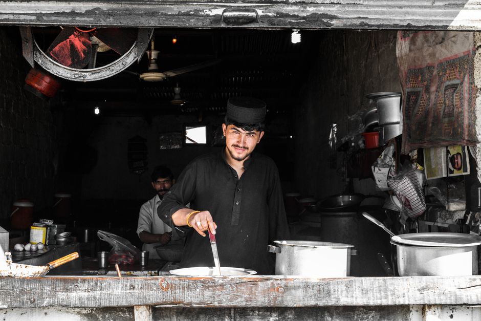 A man cooking in a traditional restaurant setting, showcasing cultural ambiance and culinary skills.