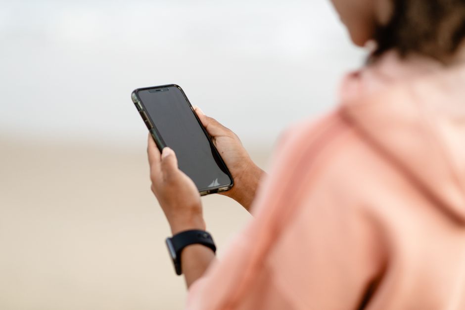 Close-up of a person using a smartphone outdoors, focusing on modern technology.