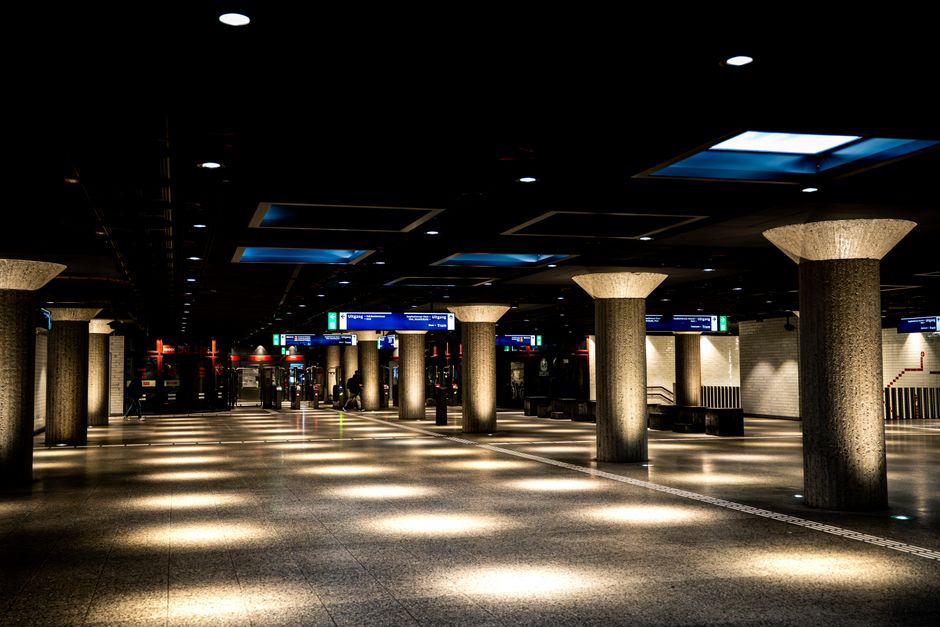 A well-lit urban subway station with concrete columns and modern architecture.