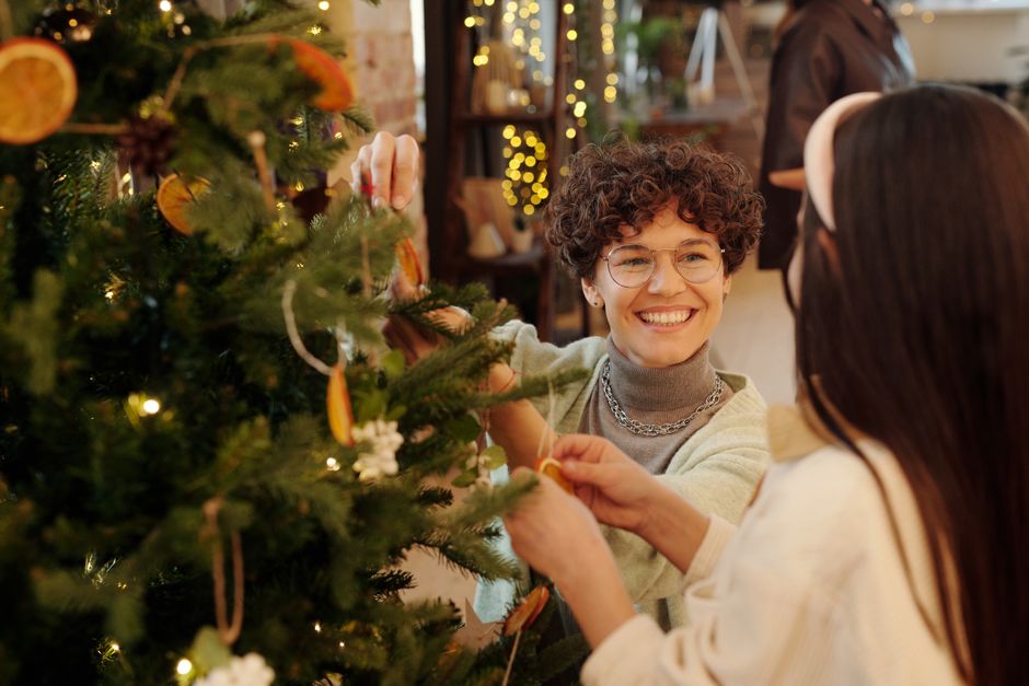 Family enjoying together time decorating a Christmas tree with joyful expressions.