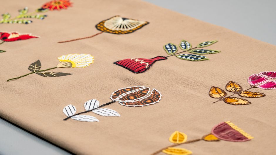 Close-up of embroidered flowers on fabric showcasing intricate craftwork.