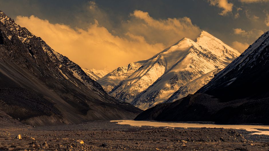 A stunning view of snow-capped peaks in northern Pakistan during a dramatic sunset.