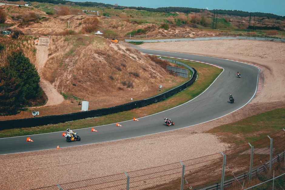 Motorcycles speeding through a curved track during a thrilling racing event outdoors.