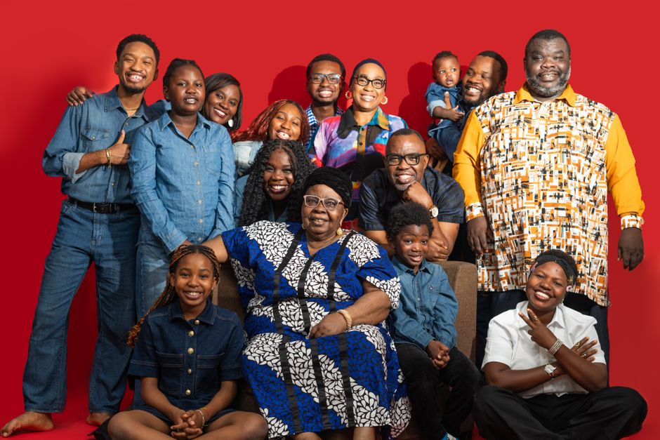 Happy family group portrait with multigenerational members in vibrant attire.