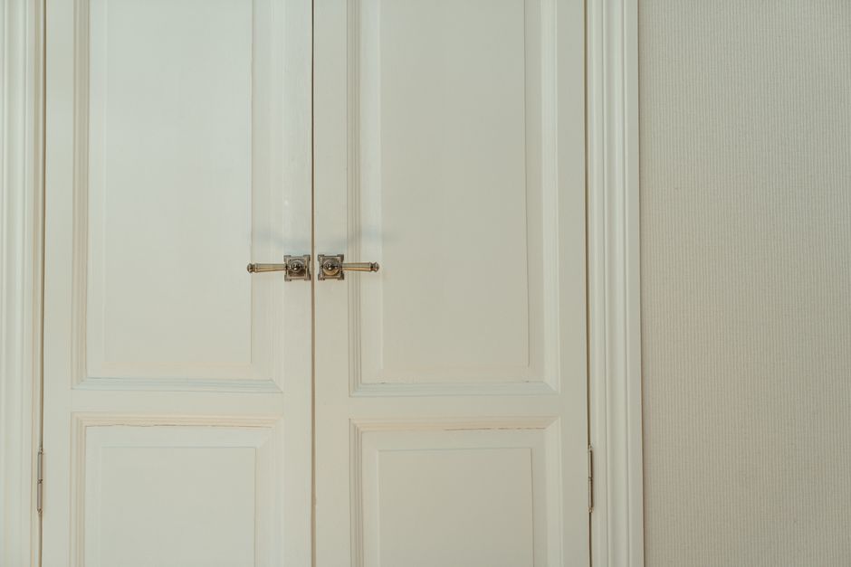 Elegant white double doors with locks, offering a stylish and secure home interior solution.