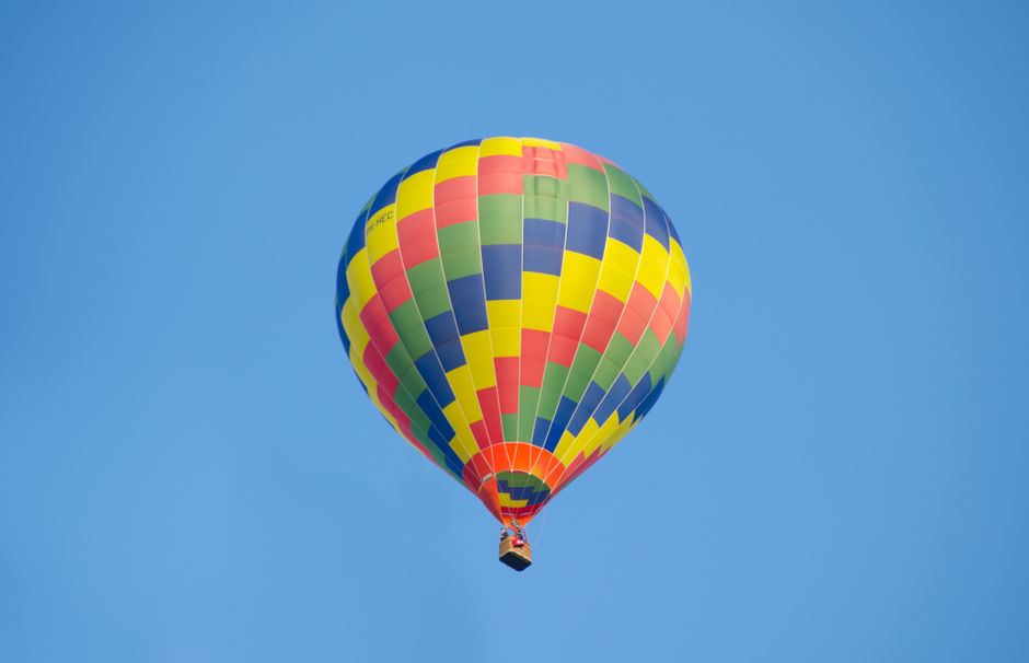 Vibrant hot air balloon floating in a bright blue sky, showcasing freedom and adventure.