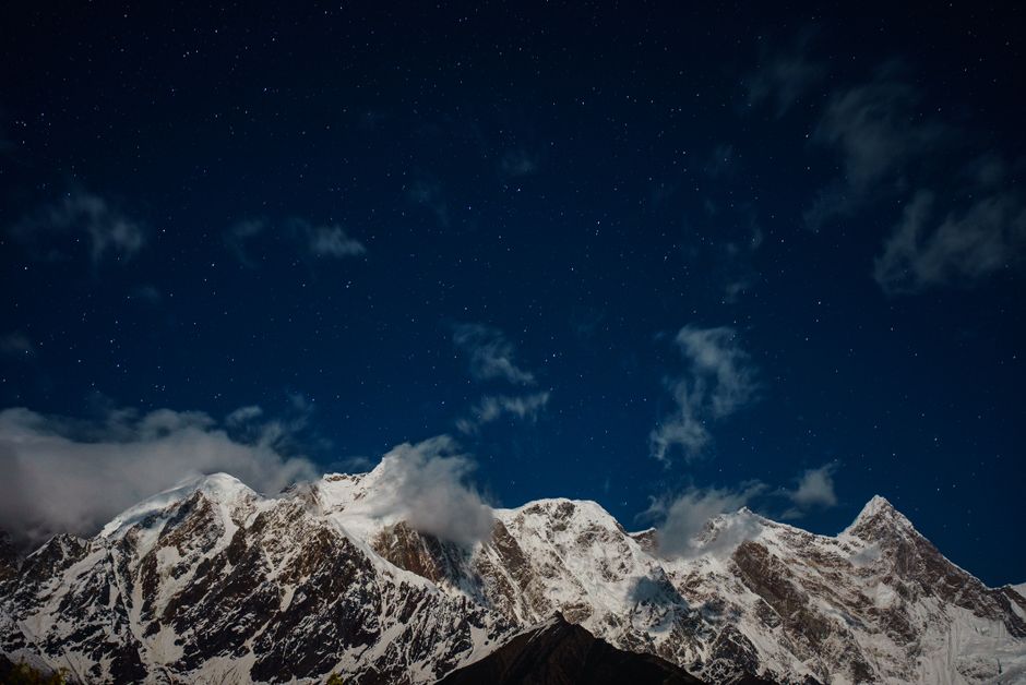 A stunning view of a snowy mountain range beneath a starlit sky, capturing nature's beauty.