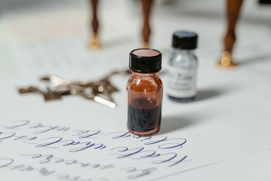 Elegant close-up of ink bottles with calligraphy script on paper, ideal for creative themes.