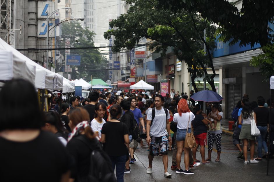 Busy street scene with diverse crowd under umbrellas in the city