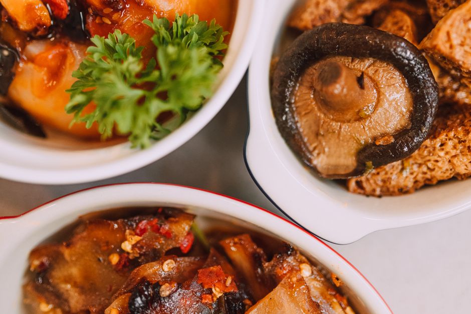 A vibrant close-up of Asian dishes featuring shiitake mushrooms and fresh herbs.
