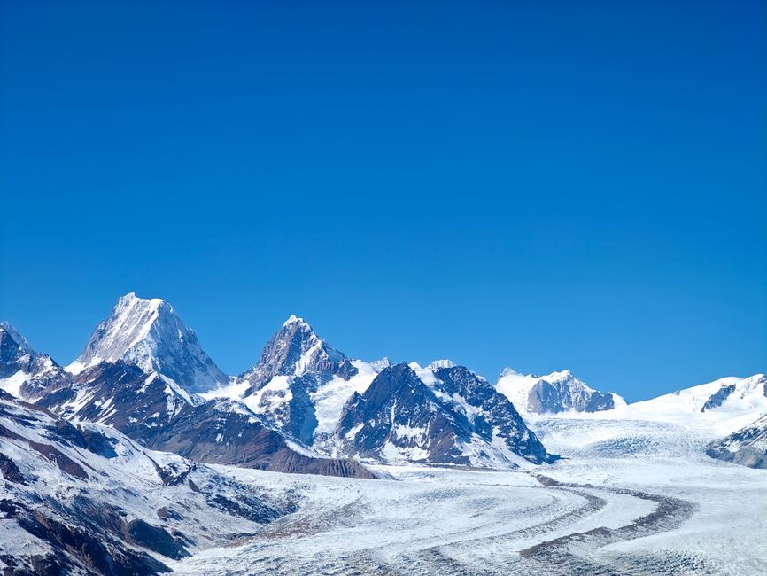 Breathtaking view of a snow-covered mountain range under a clear blue sky, showcasing natural beauty and winter's grandeur.