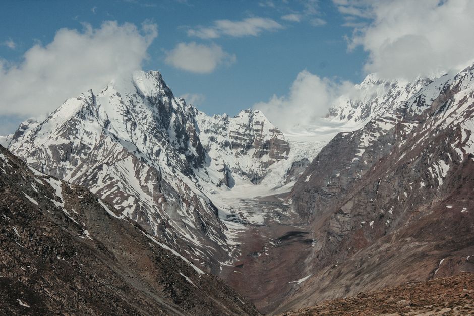 A stunning view of snow-capped mountains and a glacier under a clear blue sky.