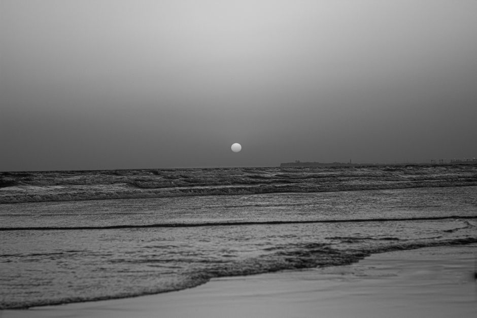 Monochrome sunset view over the ocean at Karachi beach, capturing tranquility and beauty.