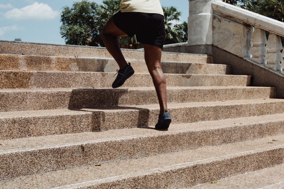 A person running up concrete stairs outdoors, showcasing fitness and exercise in an urban setting.