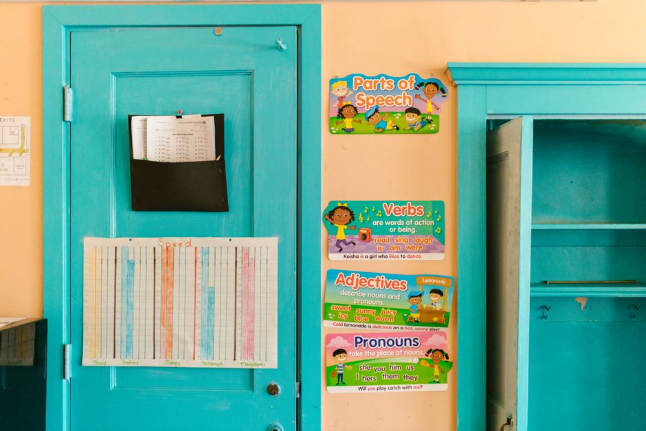 Vibrant kindergarten wall with educational posters and blue door.