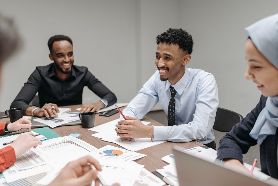 A diverse group of professionals collaborating in a modern office setting, focusing on a creative project.
